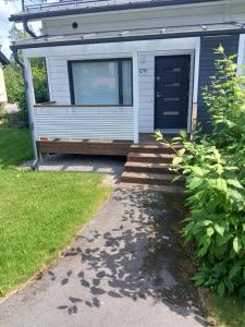 a tiny house with a blue door and stairs at Cozy Studio Järvenpää in Järvenpää