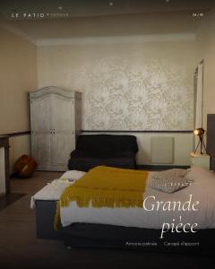 a bedroom with a bed and a wall with a flower pattern at LE PATIO in Grignan