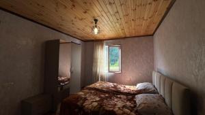 a small bedroom with a bed and a window at Cozy Corner Inn in Ushkhvanari +3 photos