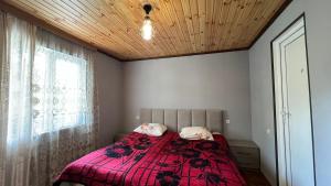 a bedroom with a bed with a pink blanket and a window at Cozy Corner Inn in Ushkhvanari
