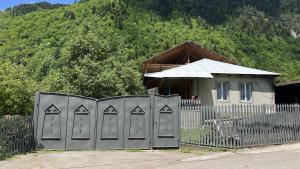 a fence with arrows on it next to a house at Cozy Corner Inn in Ushkhvanari