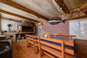 a dining room with a wooden bench and a brick wall at Apartmani Raić in Mali Lošinj