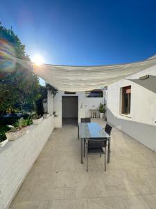 a table and chairs on a patio with a canopy at La casetta sul mare in Ortona