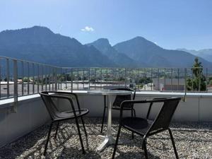two chairs and a table on a balcony with mountains at Penthouse mit Panoramaterrasse & Bergblick in Landquart in Landquart