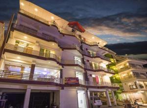 a large building with a balcony on the side of it at AYUSHKAMA COTTAGE #Naddi Sunset Point#Free Parking#cricket stadium8 km#Mcleodganj 2 km- Bhagsunag 4 km in Dharamshala