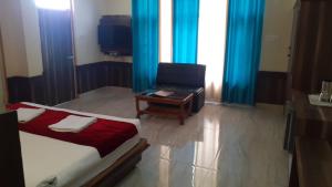 a bedroom with a bed and a chair and a desk at AYUSHKAMA COTTAGE #Naddi Sunset Point#Free Parking#cricket stadium8 km#Mcleodganj 2 km- Bhagsunag 4 km in Dharamshala