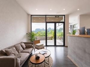 a living room with a couch and a table at Yulong River Scenic Area,Floor-to-ceiling Windows for viewing,Swimming Pool & Coffee & Butler Service,10 minutes by car from West Street in Yangshuo