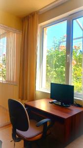 a desk with a computer and a chair in front of a window at Harmony in Sveti Vlas