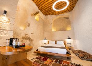 a bedroom with a bed in a stone walled room at Luvi Cave Hotel in Göreme