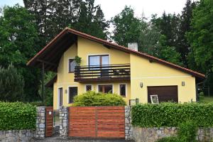 a yellow house with a fence in front of it at Apartmány Pod Lesem in Rodvínov