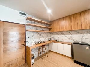 a kitchen with wooden cabinets and a counter top at Sea Suphan Villa in Ban Hua Phrong