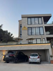 two cars parked in a garage in front of a building at EFFÉI Boutique Hotel in Sarandë