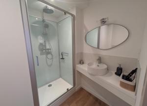 a bathroom with a shower and a sink and a mirror at la clé de la rance in Plouër-sur-Rance