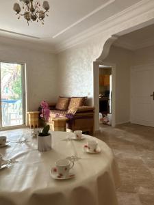 a living room with a table with cups and saucers at Piscine, plage et relaxation in Pont Blondin
