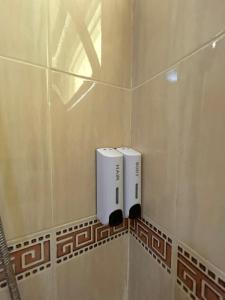 a bathroom with two soap dispensers on a tiled wall at Piscine, plage et relaxation in Pont Blondin +24 photos