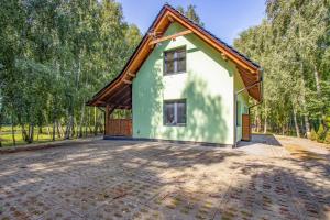 a house with a thatched roof and a driveway at Łowisko Dom ze Stawami in Trudna