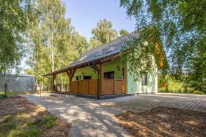 a small green house with a gambrel roof at Łowisko Dom ze Stawami in Trudna