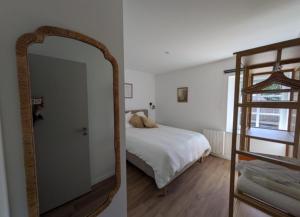 a bedroom with a mirror and a bed and a ladder at la clé de la rance in Plouër-sur-Rance