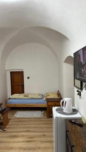 a room with two beds and a tv in it at Penzion Nattali in Poprad