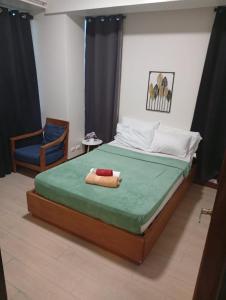 a bedroom with a large bed and a chair at Condo in Mactan Newtown in Lapu Lapu City