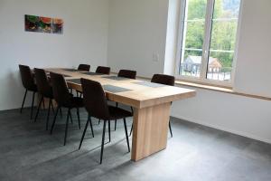 a conference room with a wooden table and chairs at Fuchs at home in Kaltbrunn
