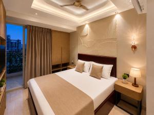 a bedroom with a large bed and a balcony at SriVa Nest in Ghaziabad