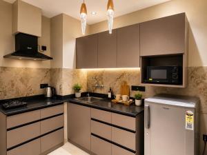 a kitchen with a sink and a refrigerator at SriVa Nest in Ghaziabad