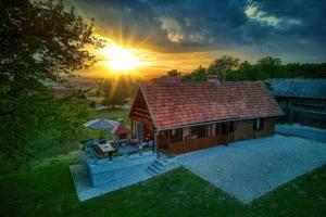 Eine Draufsicht auf ein Haus mit Sonnenuntergang im Hintergrund in der Unterkunft Aurora Silvae in Ozalj
