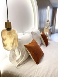 a white bed with pillows and a lamp on it at Les arches in Riom