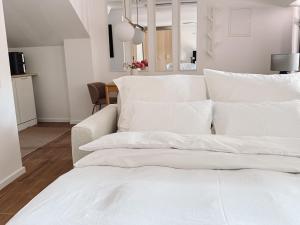 a pile of white pillows on a bed in a room at Studio Bachgeflüster in Schattendorf
