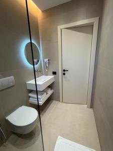 a bathroom with a toilet and a sink and a mirror at EFFÉI Boutique Hotel in Sarandë