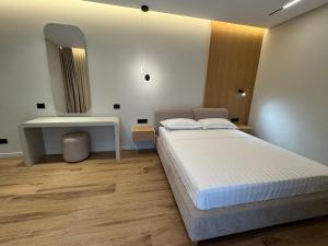 a bedroom with a bed and a sink and a mirror at EFFÉI Boutique Hotel in Sarandë