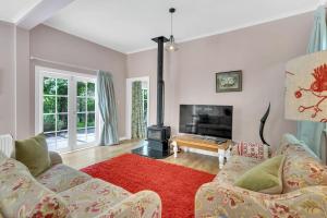 a living room with two couches and a fireplace at Rose Cottage - Tranquil retreat in Tinui +16 photos