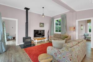 a living room with a couch and a fireplace at Rose Cottage - Tranquil retreat in Tinui