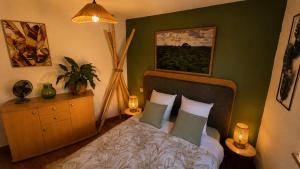 a bedroom with a bed and a painting on the wall at Maison atypique médiévale in Saint-Léonard-de-Noblat