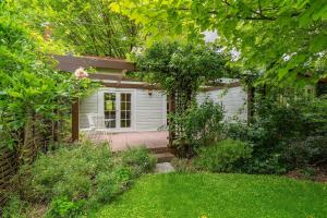 a small white shed with a porch in a yard at Rose Cottage - Tranquil retreat in Tinui