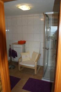 a bathroom with a shower and a white chair at Schlagerberg in Scharnstein