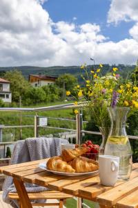 a table with a plate of bread and a vase of flowers at Willa Beskidek PLUS in Szczyrk