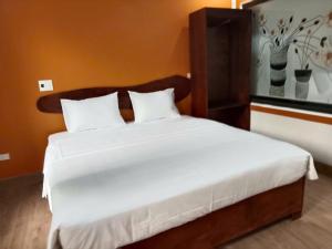 a bedroom with a large bed with white sheets at Rice Fields Mountain Homestay in Vũ Lâm