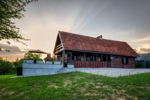 ein Holzhaus mit rotem Dach in der Unterkunft Aurora Silvae in Ozalj