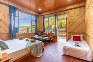 ein Schlafzimmer mit einem Bett und einem großen Fenster in der Unterkunft River Era by Naavagat in Jibhi