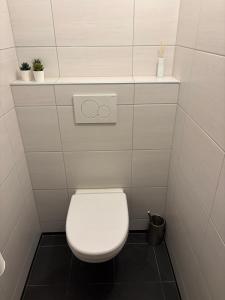 a bathroom with a white toilet with two plants at B & B it Heech in Ferwerd