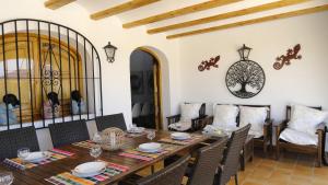 a dining room with a wooden table and chairs at El Rafalet in Jávea