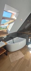 a white bath tub in a room with an attic at Agrodomki Okej - Dom Oleńka in Gardna Wielka +87 photos