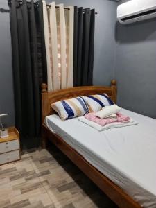 a bedroom with a bed with black curtains at Caperina del Casa-Rental in Naic