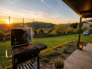 a bbq grill in a yard with the sun setting at Domek Panorama in Rymanów-Zdrój