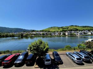 a row of cars parked in a parking lot next to a river at Boendgen's Ferienhaus mit Moselblick in Zell an der Mosel