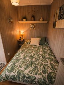 a bedroom with a bed with a green comforter at Domek Panorama in Rymanów-Zdrój