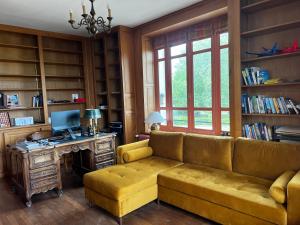 a living room with a couch and a desk with a computer at Le Chalet in Coulmier-le-Sec