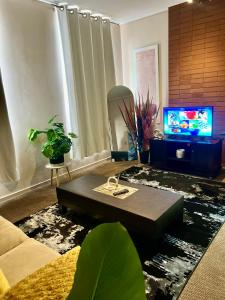 a living room with a coffee table and a tv at Warm & Cozy Diamonds Hotel in Johannesburg